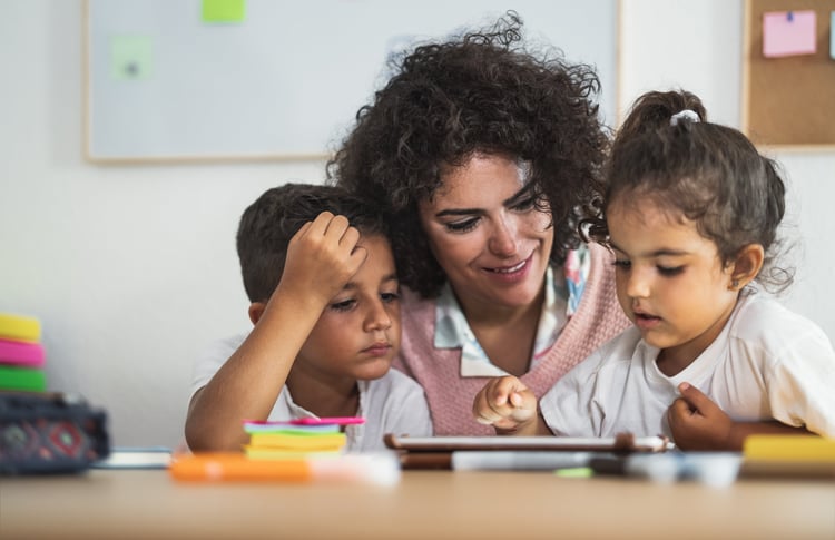 Teacher with students working on tablet